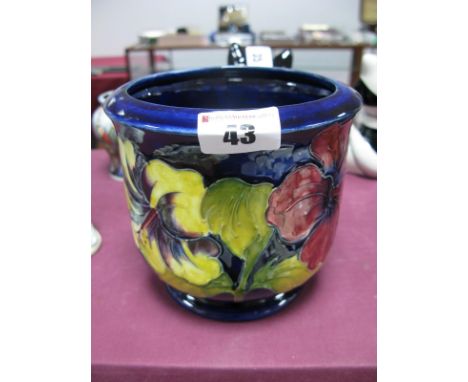 A Moorcroft Pottery Planter, painted in the Hibiscus pattern against a blue ground, impressed and painted marks, 12cm high.