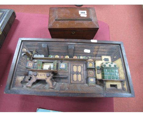 A XIX Century Mahogany Tea Caddy, with a sarcophagus top; together with a Swiss musical 3D interior scene of a log cabin. (2)