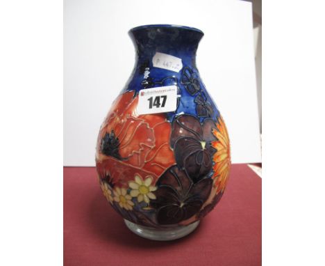 A Moorcroft Pottery Vase, painted with pansies poppies and other flowers on a blue ground, painted 'WM',  impressed marks and
