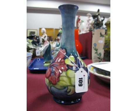 A Moorcroft Pottery Vase, of baluster form with elongated neck, painted in the 'Hibiscus' pattern on a mottled light blue gro
