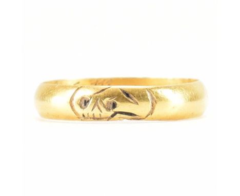 An antique gold memento mori gold band ring. The ring of D form with an inscribed skull to the outside. The interior of the r