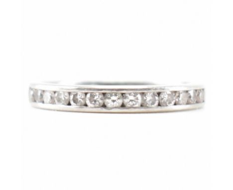 A hallmarked platinum and diamond half eternity ring. The ring being channel set with thirteen round brilliant cut diamonds. 