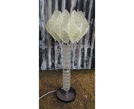 A floor-standing lamp.  Textured glass column supporting a textured lucite shade