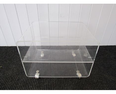 A lucite side table with middle shelf, on castors