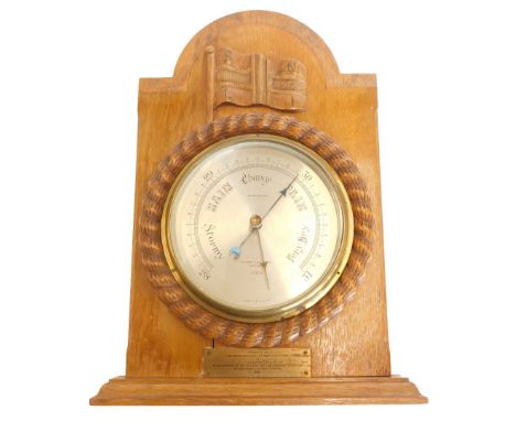 A carved oak aneroid barometer, stamped Negretti and Zambra London R/3308, presented by The Royal National Lifeboat Instituti