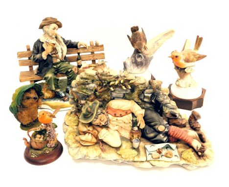 A Capodimonte figure group of a tramp seated on a bench, signed Tosca, another similar of a recumbent tramp, a figure of a he