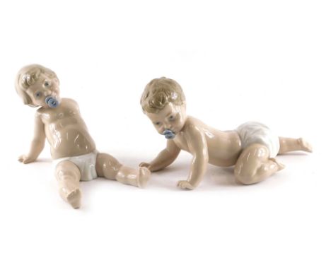 A pair of Nao porcelain piano babies, each with a dummy, 17cm high. 