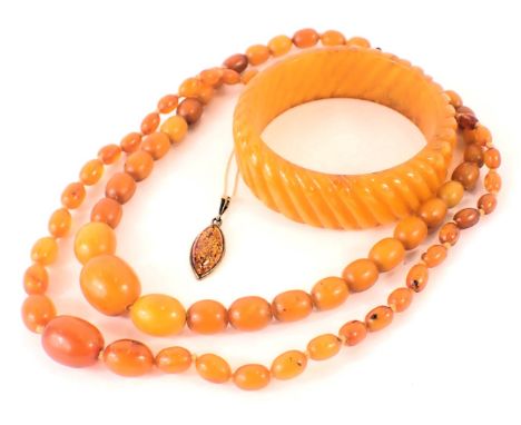 A group of amber jewellery, comprising a 9ct gold imitation amber pedant and chain, the pendant with amber flecks, in a yello