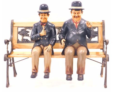 Two painted composition figures of Laurel and Hardy, 63cm high, and a stained pine bench, with Noah's ark back.