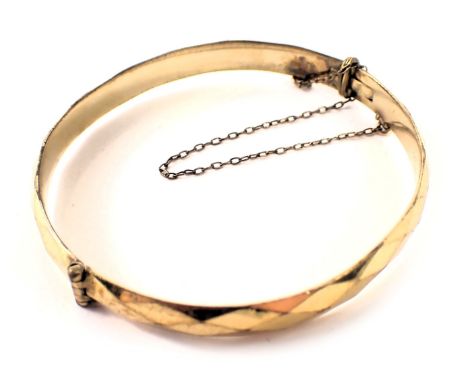 A rolled gold hinged bangle, 6.5cm diameter. 