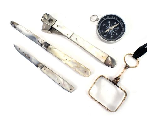 A mother of pearl handled and steel pen knife, a mother of pearl steel cigar cutter, a gilt handled magnifying glass, and a c