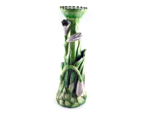 A green glazed ceramic plant stand or pedestal, decorated with pink flowers, 76cm high. 