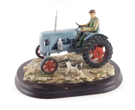 A Leonardo Collection model of a farmer with blue tractor and dog, 22cm long. 