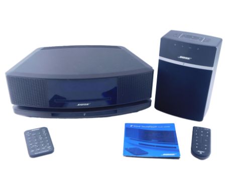 A Bose Wave Sound Touch music system, with instructions, and a Bose Bluetooth speaker. 