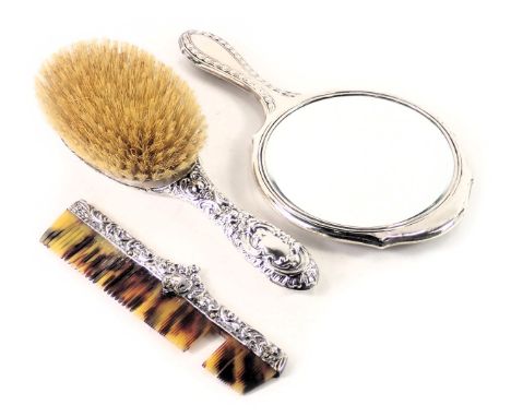 Three associated silver mounted dressing table items, to include hand mirror, brush and comb. (AF)