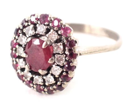 A ruby and diamond dress ring, with raised pave set stones, on a white metal band, unmarked, ring size K½, 4.6g all in, boxed