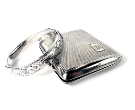 Two items of silver, comprising a silver hinged bangle, and a George V silver cigarette case, of engine turned decoration wit