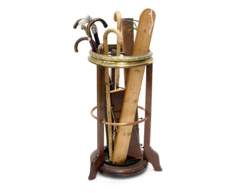 An early 20thC mahogany brass and copper banded umbrella stand, or stick stand, and various walking sticks. 