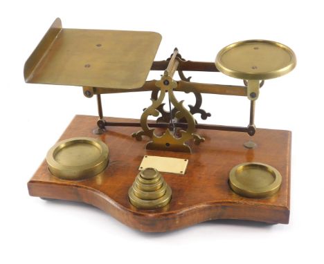 A set of brass and oak postal scales, with ivorine plaque and some weights.