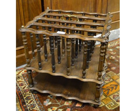 A 19th century rosewood four division Canterbury with gilt metal handle and open shelf to base, raised on wooden castors  