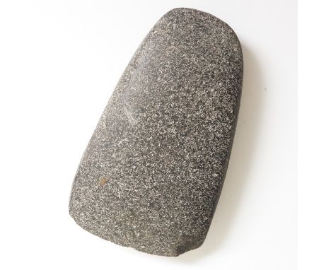 A Neolithic granite axe head, 15cm wide (chipped)