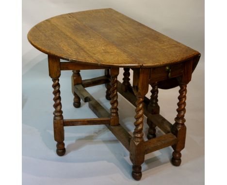 An oak oval gate leg dining table the oval top above barley turned supports joined by moulded stretchers, 116cm x 100cm oval,