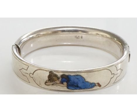 A Continental silver coloured metal bangle with wriggle work borders the centre inlaid in enamel with a weeping child, 6cm wi