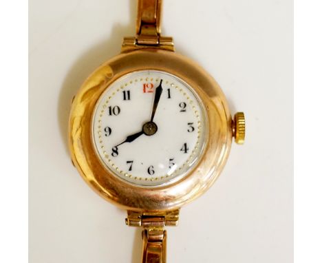 A ladies 9ct gold cased wristwatch with bubble back and front the white enamel dial with Arabic numerals, expanding 9ct gold 