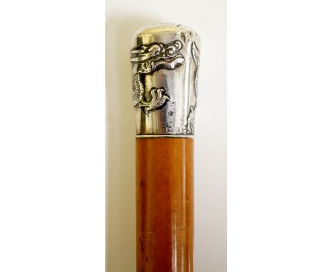 A Chinese silver topped walking stick the pommel embossed with a dragon, tapered bamboo shaft with brass ferrule, 91cm long, 