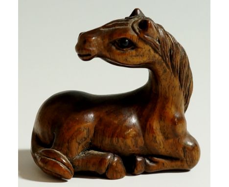 A Japanese hardwood netsuke finely carved as a horse, signed Shozan 松山, 3.5cm high, 4cm wide

 