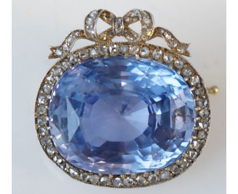 Fabergé - a cushion cut Celanese sapphire and diamond brooch, the oval stone approx. 28.19 carats with a ribbon tied border o