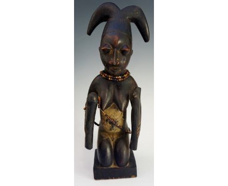 An African tribal figure of a kneeling female holding pestle and Y-shaped stick, beaded decoration, 31cm high