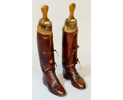 A pair of brown leather riding boots with buckled fronts above laced uppers, both with R. Coton & Co Ltd shoe trees, 66cm hig