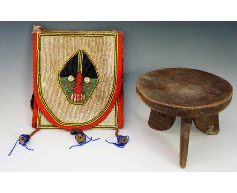 An African trunk stool the slightly dished circular top on three rudimentary flattened legs, 24.5cm diameter, 18cm high; a Yo