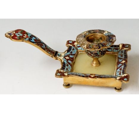 A late Victorian brass and champlevé enamel chamberstick the shaped square base with onyx panel issuing an urnular nozzle wit