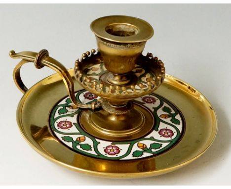 A Victorian brass and champlevé enamel chamberstick the circular base with a broad enamelled band of flower heads and scrolli