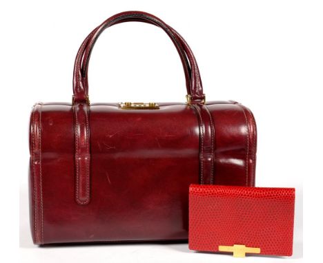 A SMYTHSON RED OSTRICH HIDE NOTEBOOK AND GOLD PLATED PEN AND A WINE COLOURED LEATHER BAG WITH COMBINATION LOCK