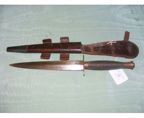 A fighting knife with ribbed grip, in leather scabbard 