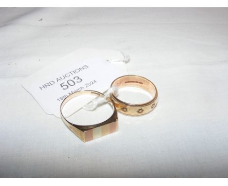 A gold wedding band together with gents ring