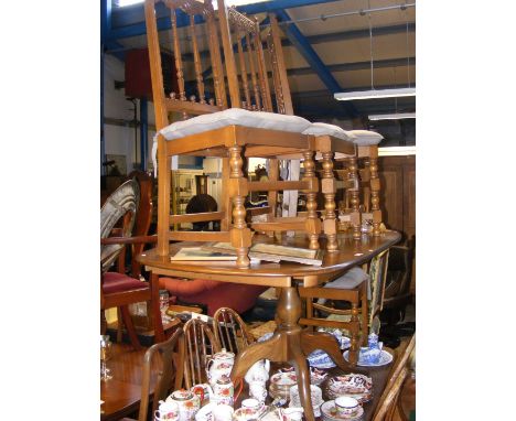 A dark wood extending Ercol dining table with four chairs