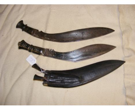 A kukri in leather scabbard, together with another kukri  CONDITION REPORT Regarding the Kukri with a plain handle:In our jud