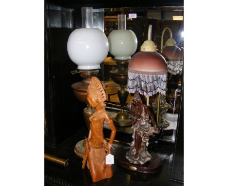 A Balinese carved wooden figure, together with Art Deco style lamp and a Victorian brass oil lamp  