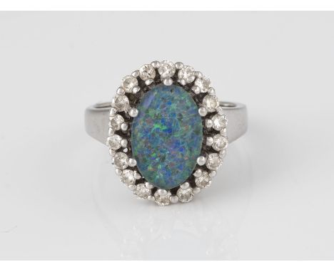 RING Weißgold. Ringmaß ca. 52, Ges.-Gew. ca. 5,6 g. Gest. 585, Caratangabe der Diamanten gemarkt. Eine ovale Opal-Triplette, 