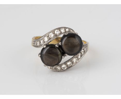 RING Gelbgold, Weißgold. Ringmaß ca. 56, Ges.-Gew. ca. 5,5 g. Gest. 750. Zwei braune Saphir-Cabochons mit Lichtreflexion, zus