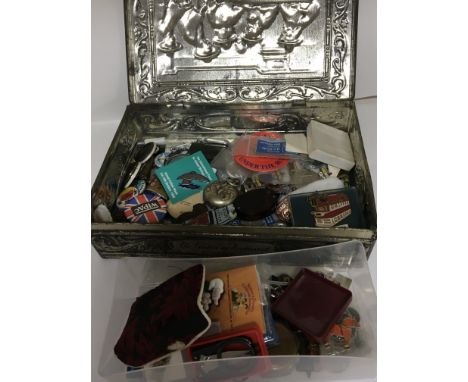 A tin containing vintage badges a silver plated sovereign case and other oddments.