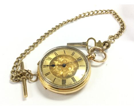 An 14ct gold key wind pocket watch with attached 9ct gold chain . Postage cat a