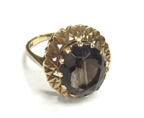 A 9ct gold ring set with a smoked quartz stone , size O. 5.1g Postage category A