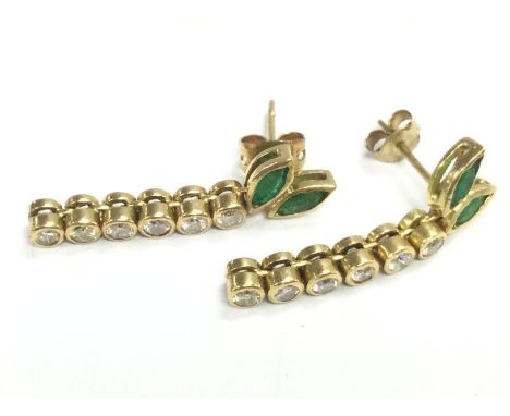 An unmarked high carat gold pair of emerald and diamond stone set drop earrings , 5.2g total weight. Postage category A