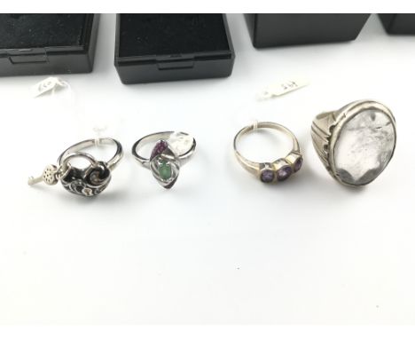 Four silver rings including an enamelled heart and lock ring and a marquise cut emerald and rubies ring. Postage B