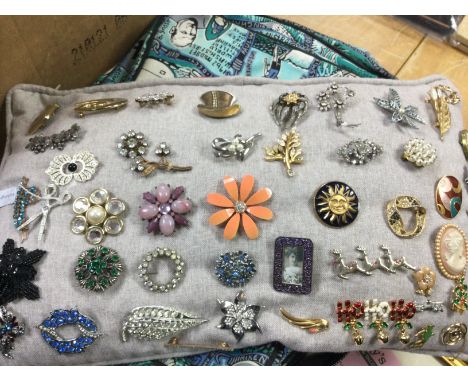 A cushion of various vintage brooches including cameos. Postage category B